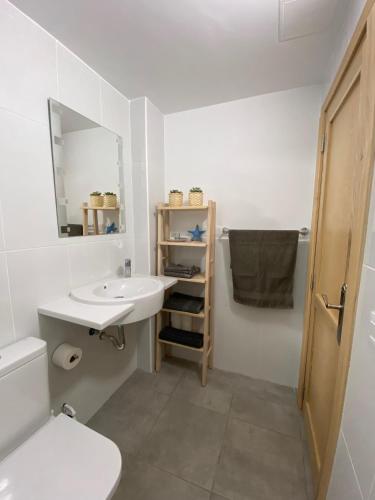 a bathroom with a sink and a toilet and a mirror at Sunny Day Deluxe in La Playa de Arguineguín