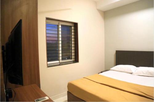 a bedroom with a bed and a window at M Square in Vellore