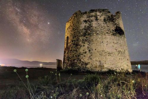 an old lighthouse under a starry sky at night at Hotel Le Torri in Arborea 