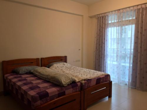 a bed in a room with a large window at AwIN’s Homestay in Ruisui