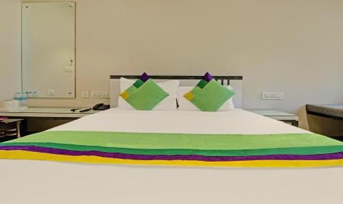a large white bed with a colorful blanket on it at Treebo Glassotel Near Ruby Hospital in Kolkata