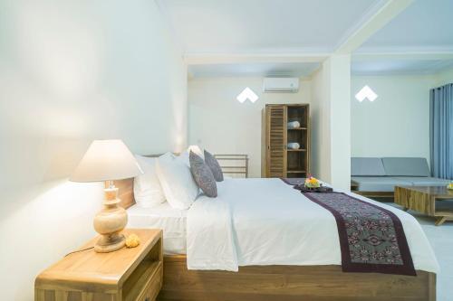 a bedroom with a bed and a table with a lamp at Vaneka Garden House in Ubud