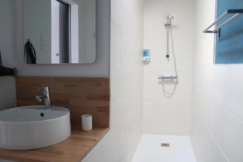 ein weißes Badezimmer mit einem Waschbecken und einem Spiegel in der Unterkunft Le Studio de Sophie in Vendôme
