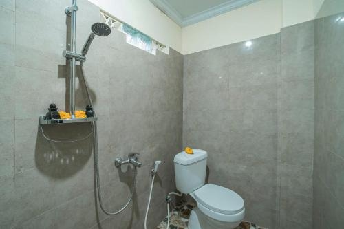 a bathroom with a shower and a toilet in it at Vaneka Garden House in Ubud