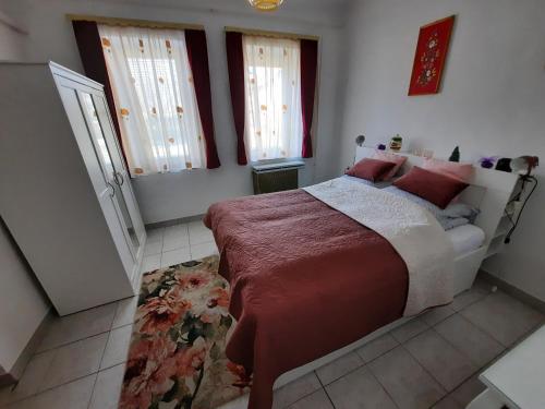 a bedroom with a large bed with red pillows at István Vendégház in Mórahalom