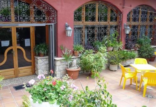 un patio con mesa, sillas y plantas en HOTEL MORELL, en El Morell