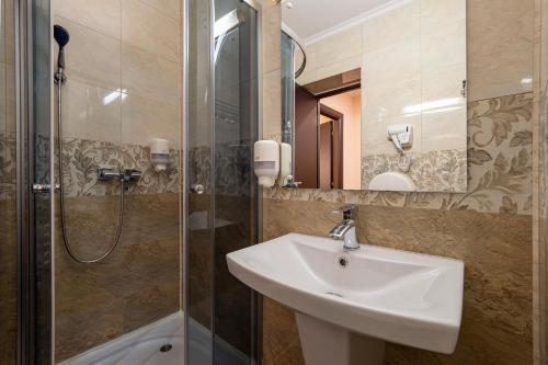 uma casa de banho com um lavatório e um chuveiro em Hotel Orient Galati em Galaţi