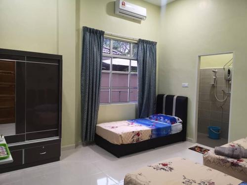 a bedroom with two beds and a shower and a mirror at VILLA SENTOSA in Kuala Terengganu