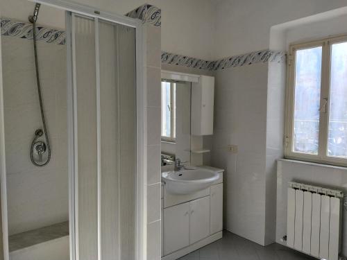 bagno bianco con lavandino e doccia di Mara House a Levanto