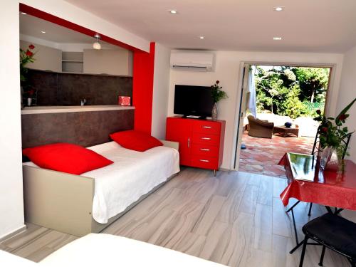 une chambre avec un lit et un mur rouge dans l'établissement Lou Trelus, à Sainte-Maxime