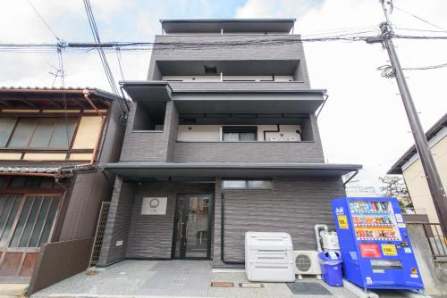 JP INN Kyotoeki Kita Gakurincho في كيوتو: مبنى امامه مدخلين فيه كرسيين