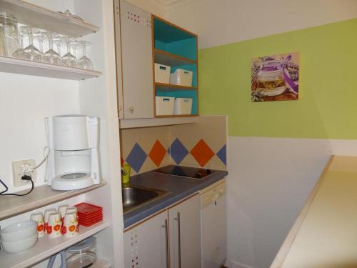 une petite cuisine avec un évier et un comptoir dans l'établissement Appartement Promenade des Bains, à Saint-Raphaël