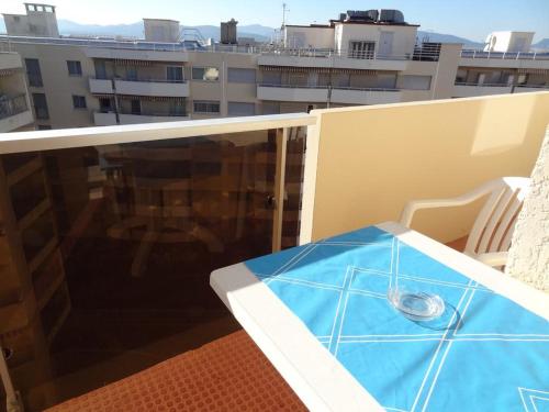 - une table sur un balcon avec vue sur un bâtiment dans l'établissement Appartement Promenade des Bains, à Saint-Raphaël