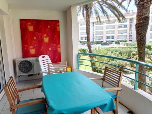 d'un balcon avec une table bleue, des chaises et une fenêtre. dans l'établissement Résidence du Port - Borghese, à Fréjus