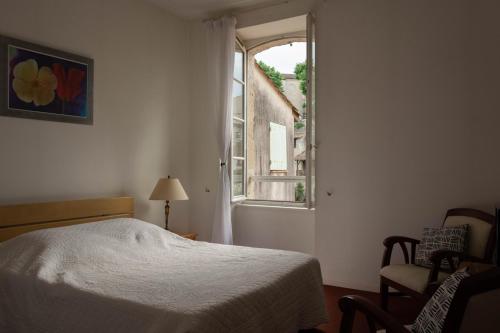 a bedroom with a bed and an open window at Les Terrasses du petit Nérac in Nérac