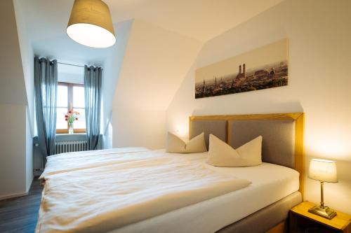 ein Schlafzimmer mit einem großen weißen Bett mit weißen Kissen in der Unterkunft Hotel Reiter Bräu in Wartenberg