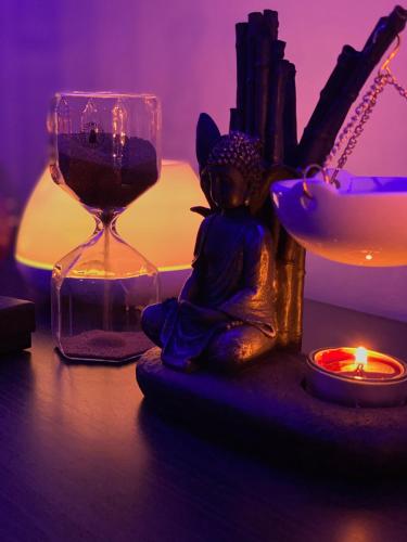 a statue of a buddha sitting on a table with a candle at Relais Stibbert Florence in Florence