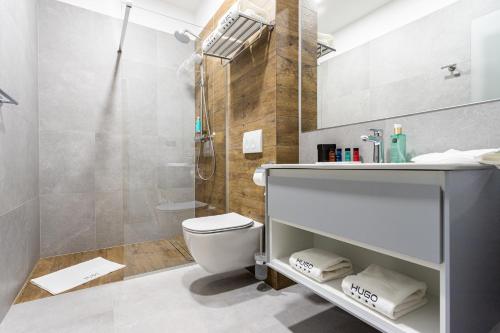 a bathroom with a shower and a toilet and a sink at Hugo Hotel in Satu Mare