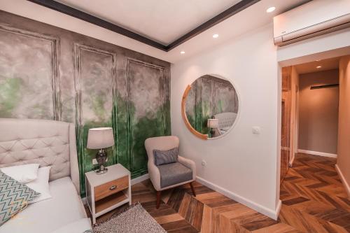 a bedroom with a bed and a chair and a mirror at Barka B'n'B - Elegant Seaview Rooms in Herceg-Novi