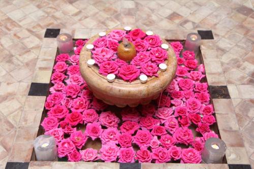 a table with a flower arrangement of pink roses at Riad Terra Bahia in Marrakech
