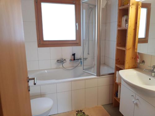Un baño con bañera, inodoro y lavabo. en Neuwertige 3 ½ Zimmer-Wohnung in Zillis/Andeer, en Zillis