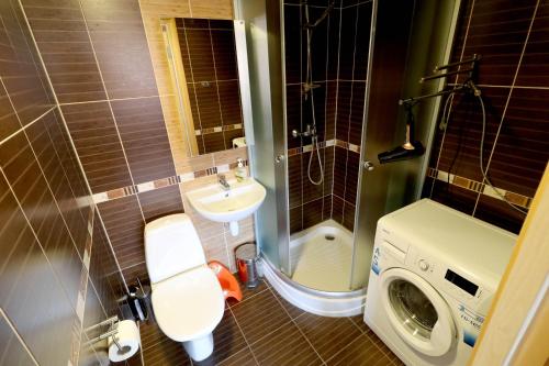 uma casa de banho com um lavatório e uma máquina de lavar roupa em Õhtukese Apartment em Pärnu
