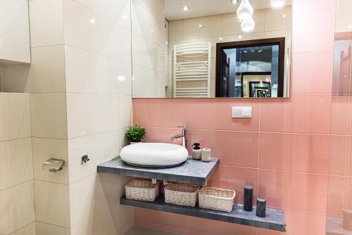 a bathroom with a sink and a mirror at Bulwar Apartament in Głogów