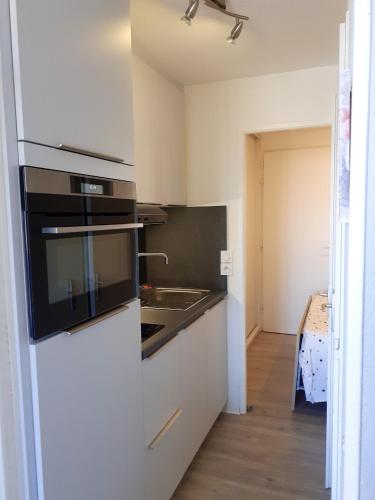 une cuisine avec un évier et une cuisinière four supérieur dans l'établissement Appartement confortable avec vue sur la mer à Quiberon - 25 m², à Quiberon