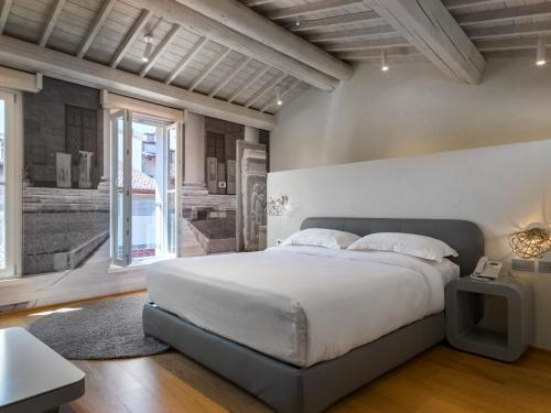 ein Schlafzimmer mit einem großen Bett und einem großen Fenster in der Unterkunft Lords of Verona Luxury Apartments in Verona