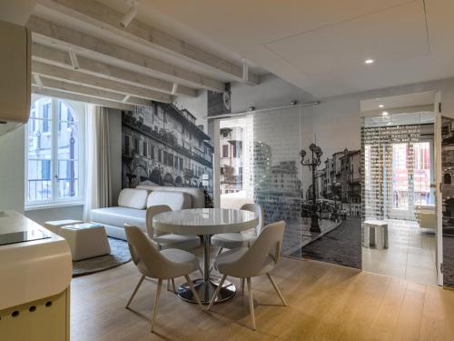 a living room with a table and chairs and a bed at Lords of Verona Luxury Apartments in Verona