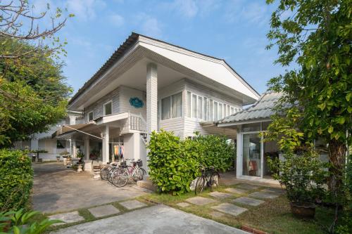a white house with bikes parked in front of it at Banlomnow in Chiang Rai