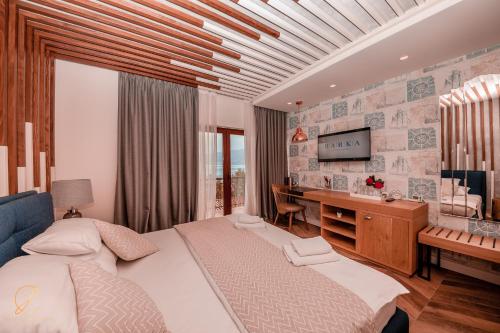 a bedroom with a bed and a desk and a television at Barka B'n'B - Elegant Seaview Rooms in Herceg-Novi