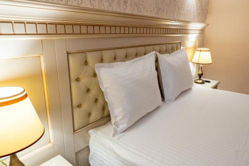 a bedroom with a bed with white pillows at Hotel Orient Galati in Galaţi
