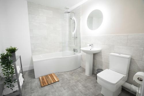 uma casa de banho com uma banheira, um WC e um lavatório. em Litton Mill Retreat, Luxury Converted Mill em Cressbrook