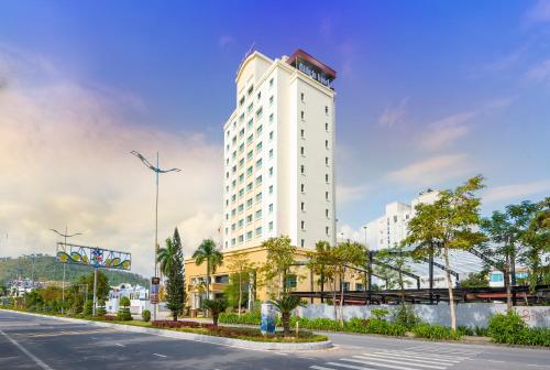 a tall white building on the side of a street at Mithrin Hotel Halong in Ha Long