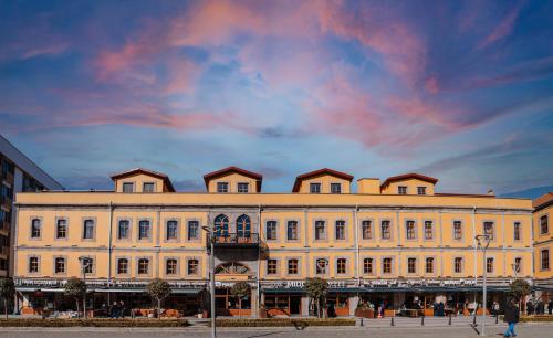 ein großes weißes Gebäude mit wolkigem Himmel dahinter in der Unterkunft TS Park Hotel in Trabzon