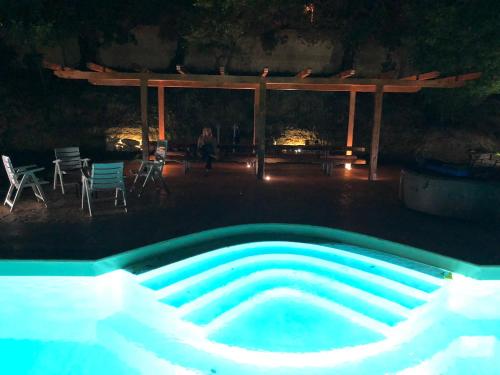 a swimming pool at night with a table and chairs at Tenuta Lisetta in Monterotondo