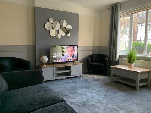 sala de estar con sofá y TV en Tudors, en Chelmsford