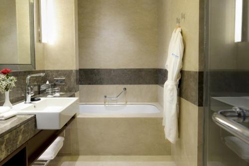 a bathroom with a sink and a bath tub at Wyndham Grand Istanbul Europe in Istanbul