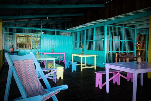 Habitación con mesas, sillas y paredes azules. en Refugio Mr Jerry Eco Hostal en Bahía Solano