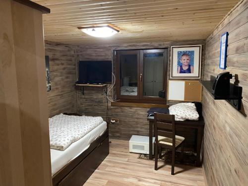 Cette petite chambre comprend un lit et un bureau avec une chaise. dans l'établissement Ubytovanie v prírode, à Čaka