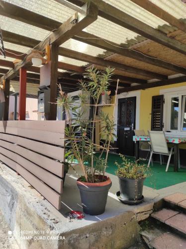 a patio with two potted plants on a porch at Ellena Sunshine in Opatija