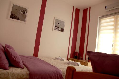 a bedroom with a bed with red stripes on the wall at Biserna Dolina Uvac in Sjenica