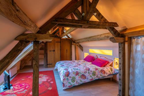 une chambre avec un lit dans une pièce avec des plafonds en bois dans l'établissement Longère PROCHE LOCHES, à Ciran