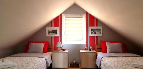 a attic bedroom with two beds and a window at Biserna Dolina Uvac in Sjenica