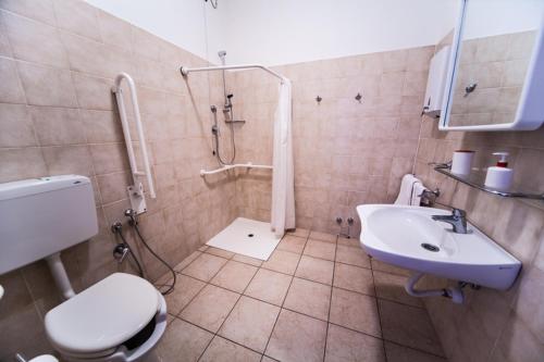 La salle de bains est pourvue de toilettes, d'un lavabo et d'une douche. dans l'établissement Rifugio Natura Delta Po, à San Rocco