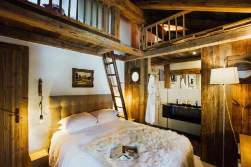 ein Schlafzimmer mit einem großen Bett mit einer Leiter in der Unterkunft Chalet Debussy - Our elegant farmhouse in Montriond