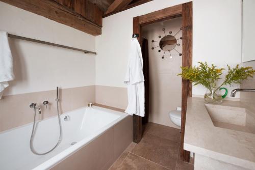 ein Bad mit einer Badewanne und einem WC in der Unterkunft Chalet Debussy - Our elegant farmhouse in Montriond