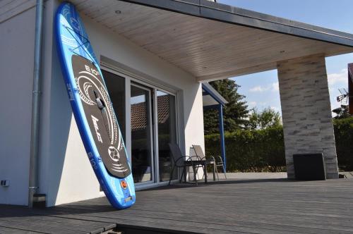 uma prancha de surf pendurada no lado de um edifício em Villa Aurea em Nowe Warpno