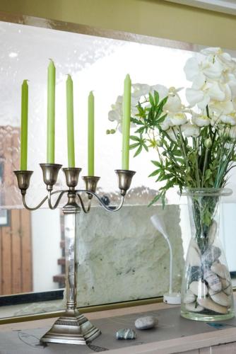 a candle holder and a vase with white flowers at Le Parasol in Ars-en-Ré